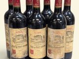 six bouteilles de vin sont alignées sur une surface blanche