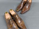 two pairs of brown shoes with laces on them on a gray surface