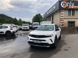 un SUV blanc garé devant un immeuble, sur un parking