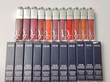 lip glosses are lined up in a row on a white surface