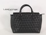 un sac à main noir posé sur une boîte blanche