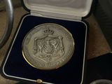 three silver coins in a case on a table