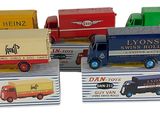 plusieurs camions jouets sont alignés sur une surface blanche