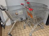 two shopping carts sitting in the corner of a room