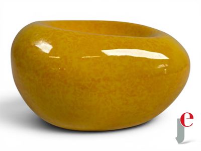 a large yellow bowl sitting on a white surface