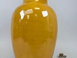 paire de vases en céramique jaune avec poignées en métal sur fond blanc