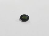 a close up of a green sapphire stone on a white surface