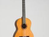 an acoustic guitar hanging on a wall with a white background