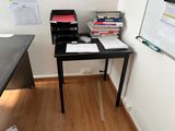 a small desk with a lot of books on top of it