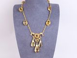 the necklace is made of gold metal and has a large crystal pendant