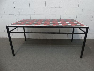 une table à carreaux rouges et blancs posée sur un sol en béton
