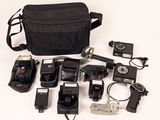 a black bag with a camera, flash, camera and other items