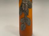 an orange vase with a bird on it sitting on top of a table
