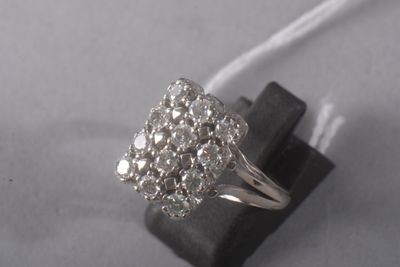 une photo d'une bague sertie de diamants posée sur un morceau de bois noir