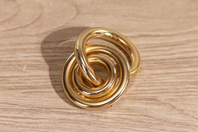 une photo d'une bague en or posée sur une table en bois