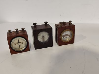 trois petites horloges en bois posées les unes à côté des autres sur une surface blanche