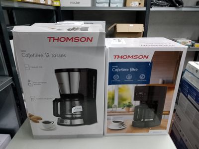deux cartons contenant des cafetières posés sur une table