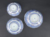 three blue and white plates with designs on them sitting on a table