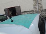 a white car with a blue roof parked in front of a building