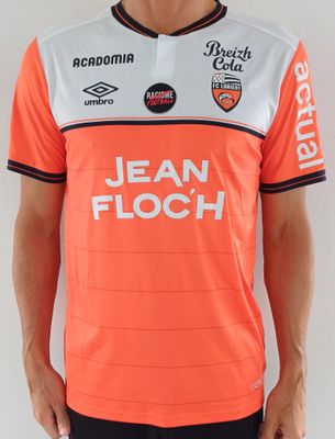 Cet homme porte un maillot de foot orange et blanc.