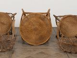 three wicker chairs and a basket on a wooden floor