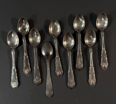 six cuillères en argent sont alignées sur une surface noire