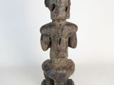 an image of a statue of a person sitting on a stool