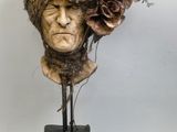 une sculpture représentant une tête d'homme ornée de fleurs
