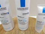 three bottles of lotion sitting on a wooden tray