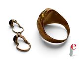 a gold ring and a pair of scissors on a white surface