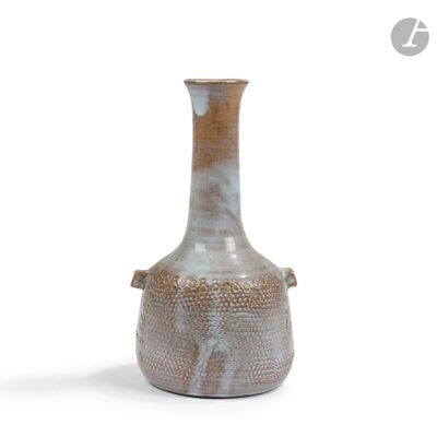 un petit vase posé sur une surface blanche