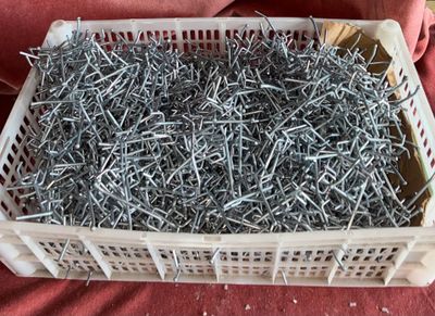 a basket full of nails sitting on a red cloth