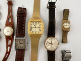 many different types of watches displayed on a white surface