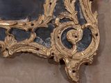 a mirror on the wall with a gold frame on it