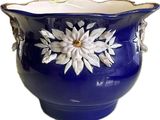 un vase bleu orné d'une fleur blanche