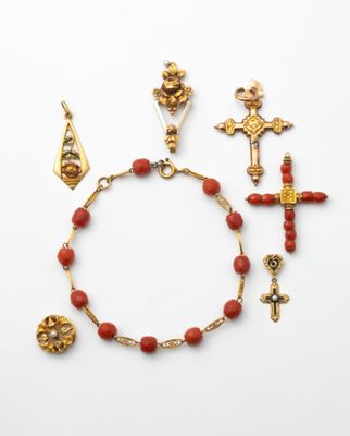 an assortment of gold and coral beaded bracelets and earrings
