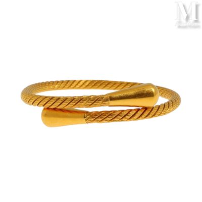 gros plan d'un bracelet en or sur fond blanc