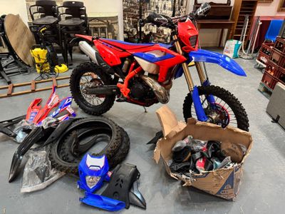 une moto tout-terrain rouge et bleue garée dans un garage