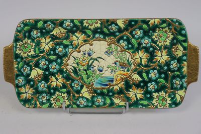 une assiette verte et dorée ornée de fleurs et d'oiseaux