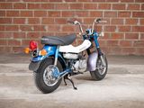 a small blue motorcycle parked in front of a brick wall