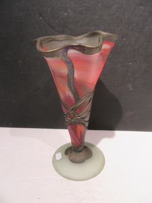 a glass vase with a bird on it on a table