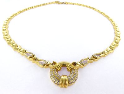 a gold necklace with a heart shaped pendant on a chain