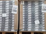 deux palettes chargées de cartons contenant des matelas dans un entrepôt