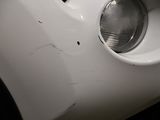 a close up of a white car ' s front bumper