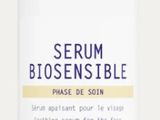 un gros plan d'un flacon de sérum posé sur une surface blanche