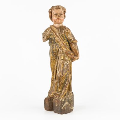 an old wooden statue of a man holding a cross