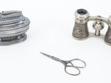 a pair of binoculars and a pair of scissors on a white surface