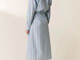 the woman is wearing a blue and white striped shirt dress