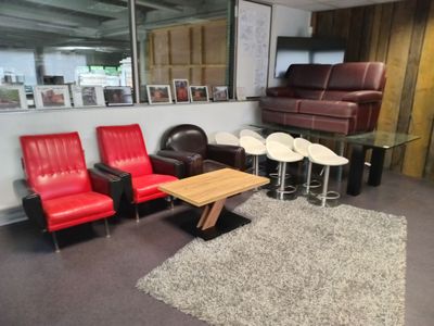 a living room with red leather chairs and a coffee table