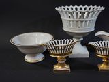 three white and gold vases and a bowl on a black background